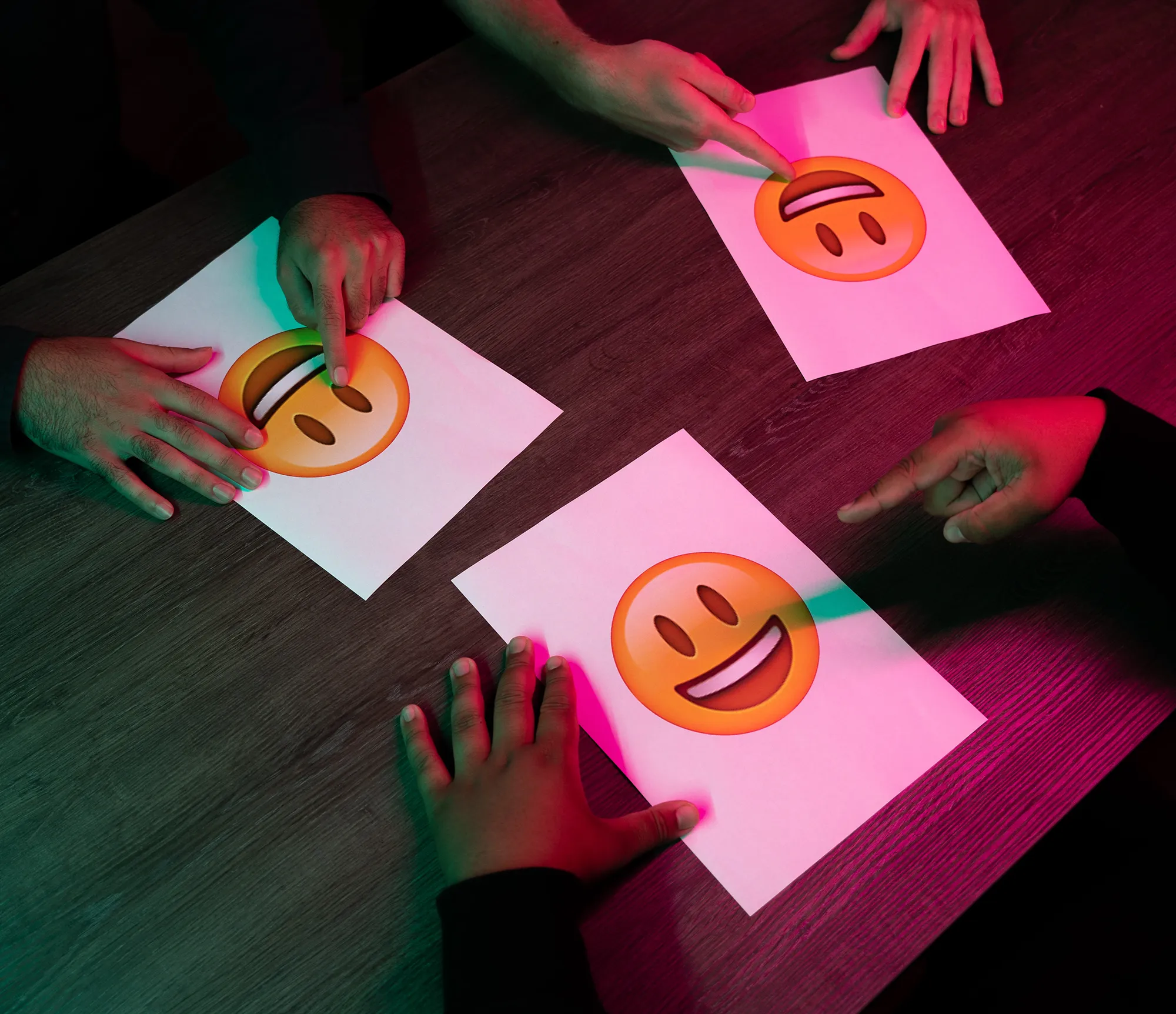 Mensen wijzen naar A4 blaadjes met een smiley emoticon